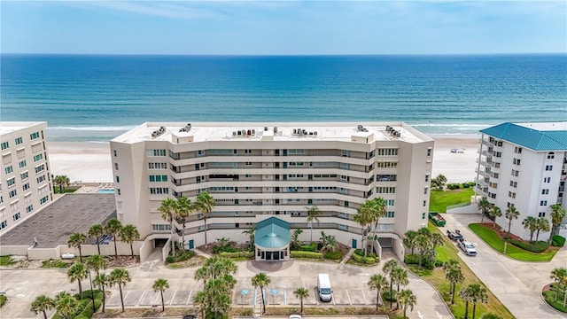 drone / aerial view with a water view and a beach view