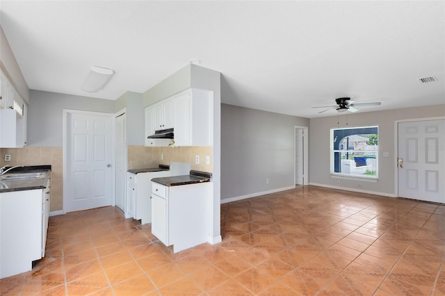 kitchen featuring ceiling fan, backsplash, light tile patterned floors, and white cabinets