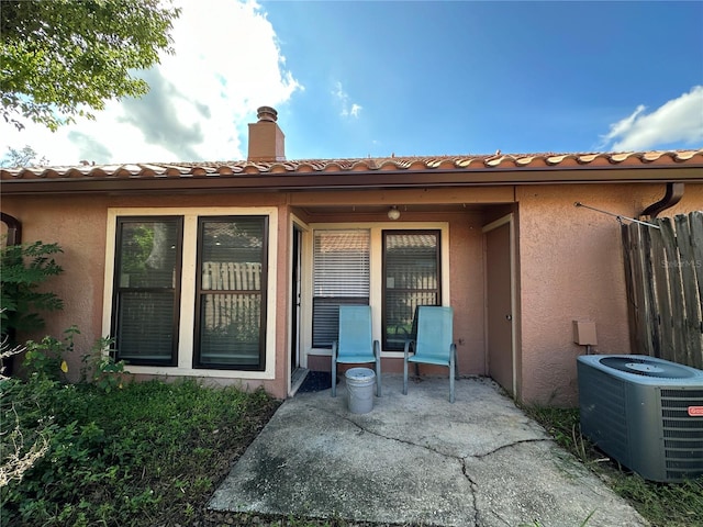 back of property featuring central air condition unit and a patio area