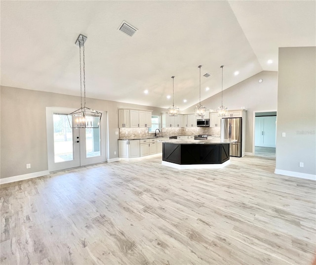 kitchen with light wood-type flooring, stainless steel appliances, a center island, and pendant lighting