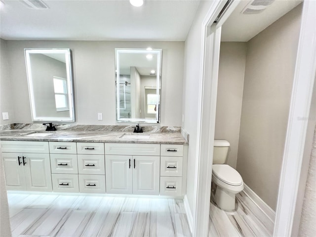 bathroom with double sink vanity, tile patterned floors, and toilet