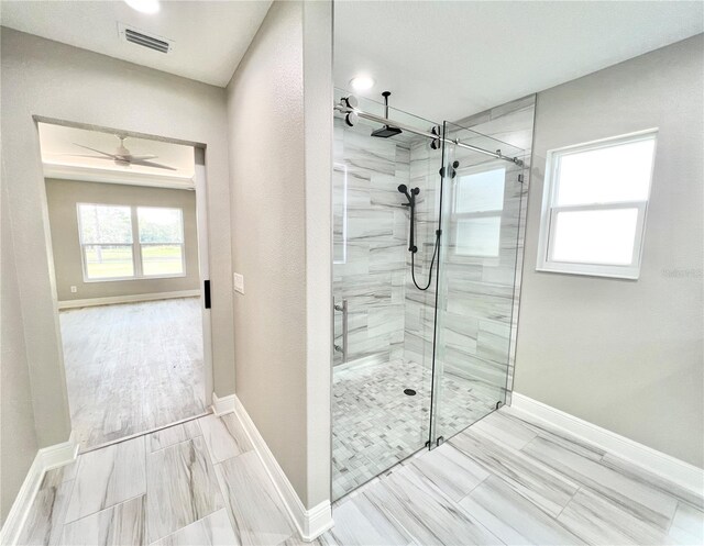 bathroom with a shower with shower door, tile patterned flooring, and ceiling fan