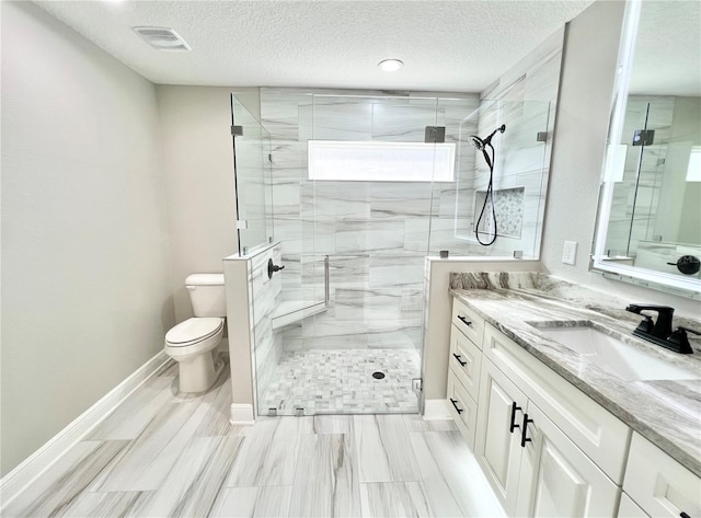 bathroom with a textured ceiling, toilet, tile patterned flooring, a shower with door, and vanity