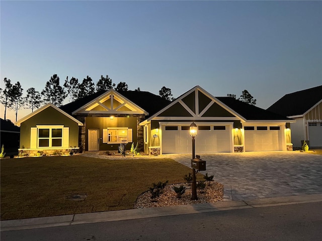 craftsman-style house featuring a yard and a garage