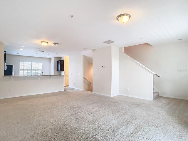 unfurnished living room featuring light carpet