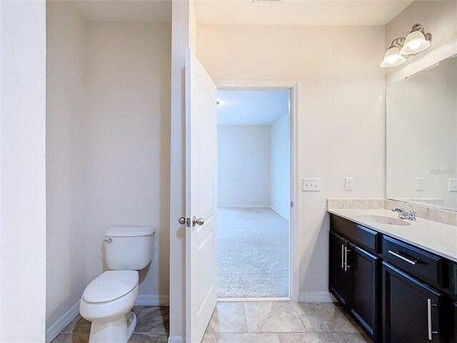 bathroom featuring tile patterned floors, vanity, and toilet