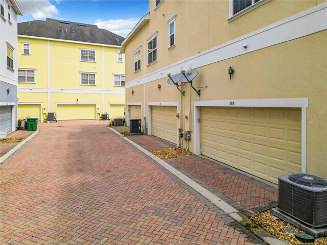 exterior space with a garage and central AC