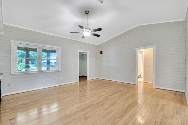 unfurnished living room with light wood-type flooring, vaulted ceiling, ceiling fan, wood walls, and ornamental molding