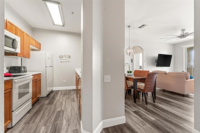 kitchen with dark wood-type flooring, electric stove, and ceiling fan with notable chandelier