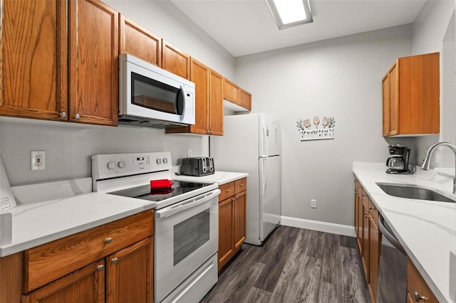 kitchen with white appliances, sink, and dark wood-type flooring