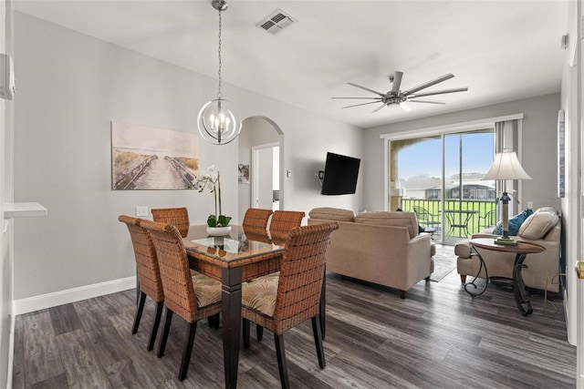 dining area featuring ceiling fan with notable chandelier and dark hardwood / wood-style floors