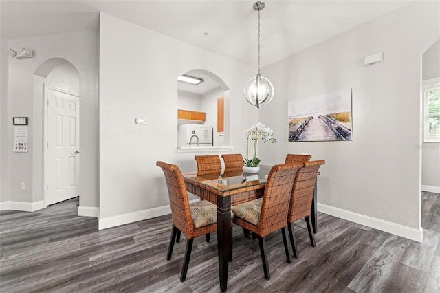 dining room with dark hardwood / wood-style floors and a chandelier