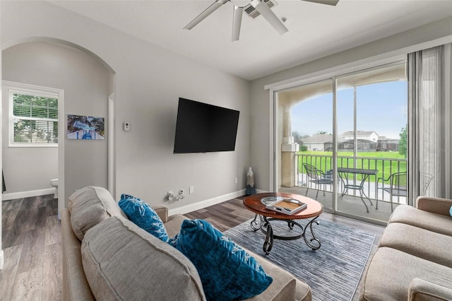 8105 Coconut Palm Way Unit 203, Kissimmee, FL 34747 - living room with arched walkways, a ceiling fan, and wood finished floors
