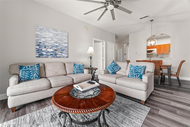 living room with dark hardwood / wood-style flooring and ceiling fan