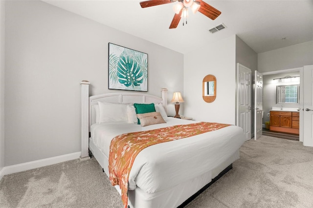 bedroom with connected bathroom, ceiling fan, and light carpet