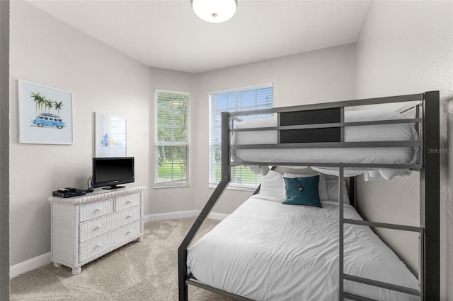 bedroom featuring light colored carpet and multiple windows