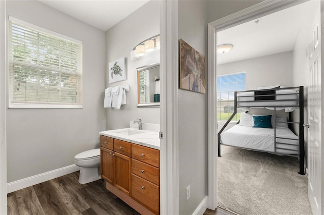 bathroom with toilet, vanity, and hardwood / wood-style flooring