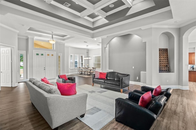 living room with a wealth of natural light, ornamental molding, a towering ceiling, and coffered ceiling