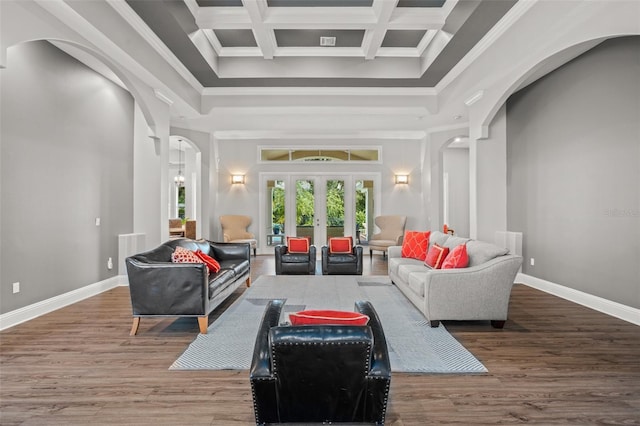 interior space with beam ceiling, coffered ceiling, a high ceiling, crown molding, and wood-type flooring