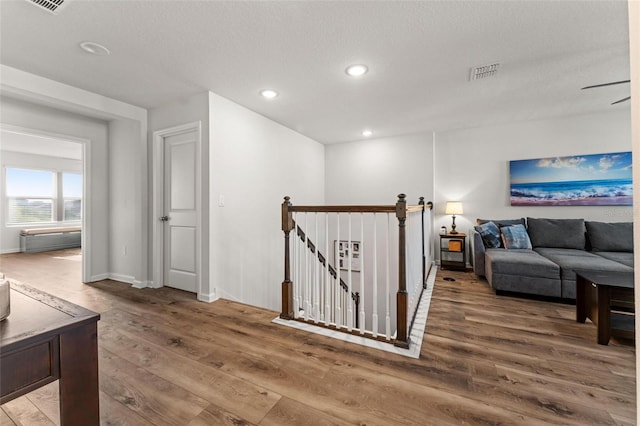 corridor featuring a textured ceiling and hardwood / wood-style flooring