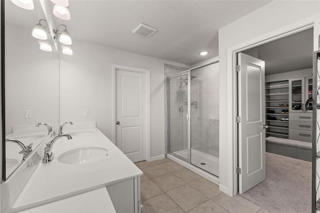 bathroom with tile patterned flooring, an enclosed shower, and dual bowl vanity