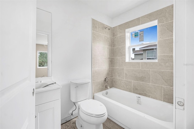 full bathroom featuring vanity, tiled shower / bath combo, and toilet