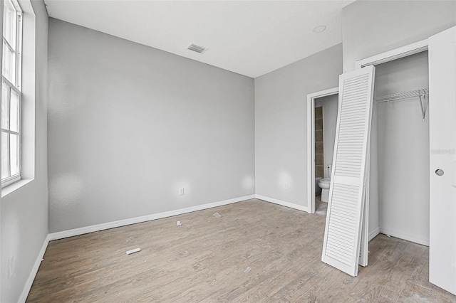 unfurnished bedroom featuring a closet and light wood-type flooring