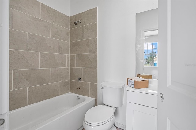 full bathroom featuring vanity, tiled shower / bath, and toilet