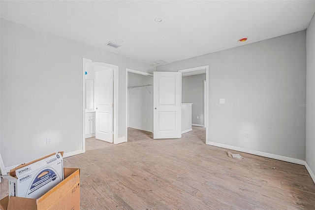 unfurnished bedroom featuring light hardwood / wood-style floors, a closet, and a textured ceiling