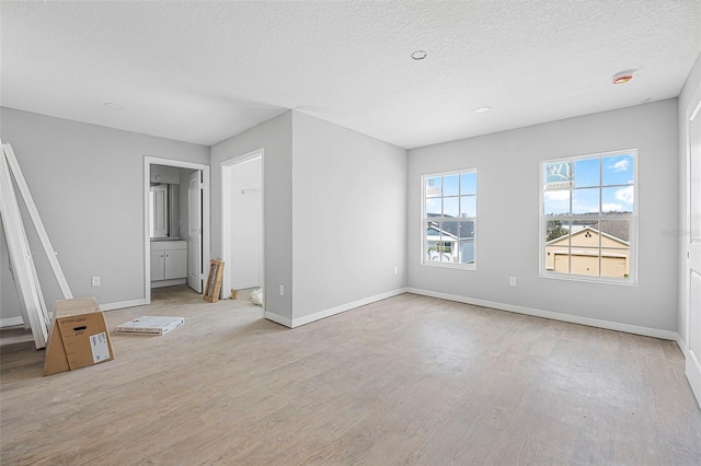 empty room featuring light hardwood / wood-style floors and a textured ceiling