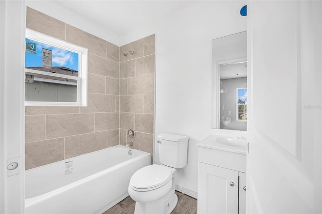 full bathroom with vanity, tiled shower / bath combo, wood-type flooring, and toilet