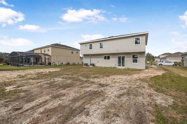 back of property featuring a lanai and central air condition unit