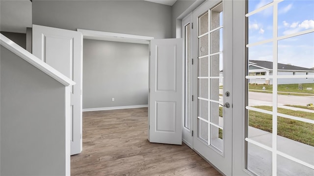 doorway with baseboards and wood finished floors