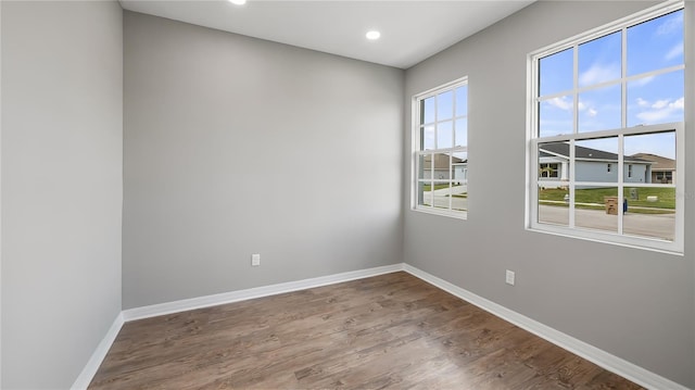 spare room featuring recessed lighting, baseboards, and wood finished floors