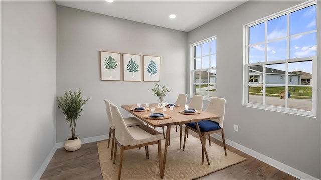 dining room featuring baseboards, wood finished floors, and recessed lighting