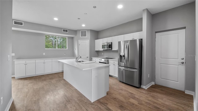 kitchen featuring appliances with stainless steel finishes, visible vents, a sink, and white cabinetry