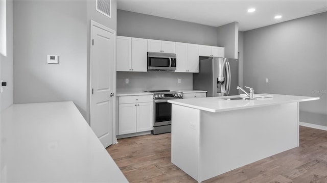 kitchen featuring white cabinetry, light wood-style flooring, appliances with stainless steel finishes, and a sink