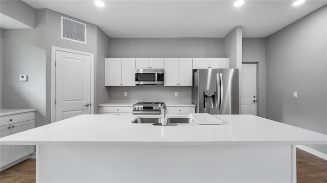 kitchen with a kitchen island with sink, a sink, visible vents, light countertops, and appliances with stainless steel finishes