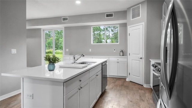 kitchen featuring visible vents, stainless steel appliances, a sink, and light countertops