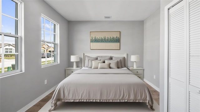 bedroom featuring dark wood-style floors, visible vents, and baseboards