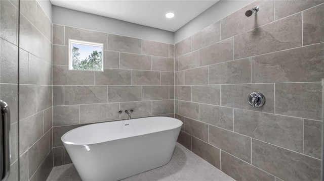 bathroom featuring a freestanding bath and tiled shower