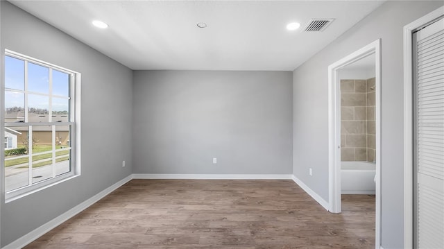 unfurnished room featuring baseboards, visible vents, wood finished floors, and recessed lighting