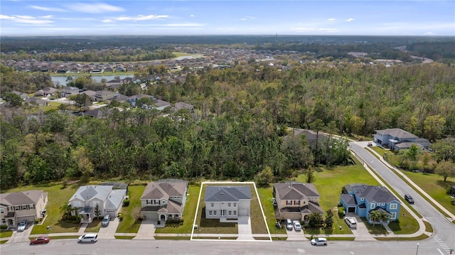 drone / aerial view featuring a residential view and a view of trees