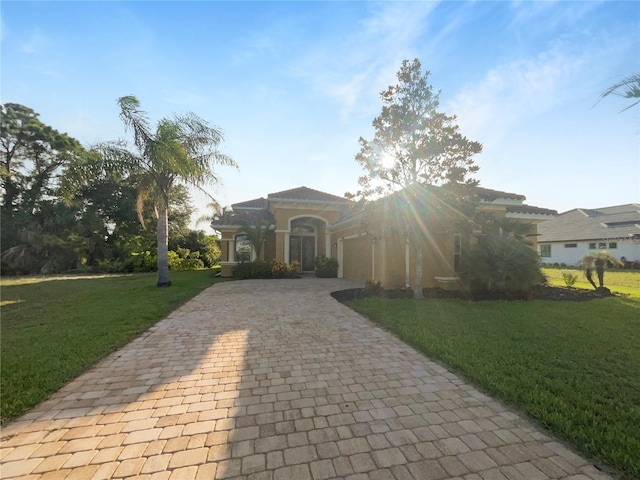 view of front of property with a garage, a front lawn, and decorative driveway