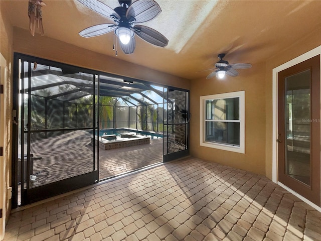 unfurnished sunroom with a ceiling fan