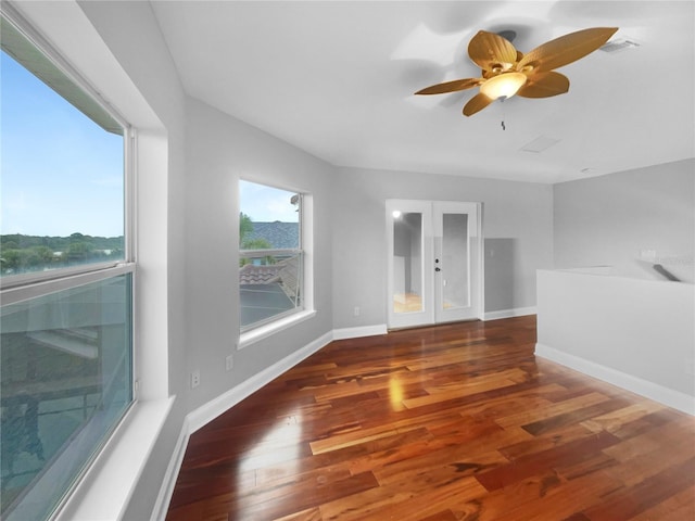 spare room with visible vents, baseboards, a ceiling fan, dark wood-type flooring, and french doors