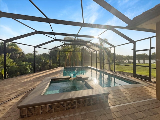 view of pool with glass enclosure, a pool with connected hot tub, and a patio area