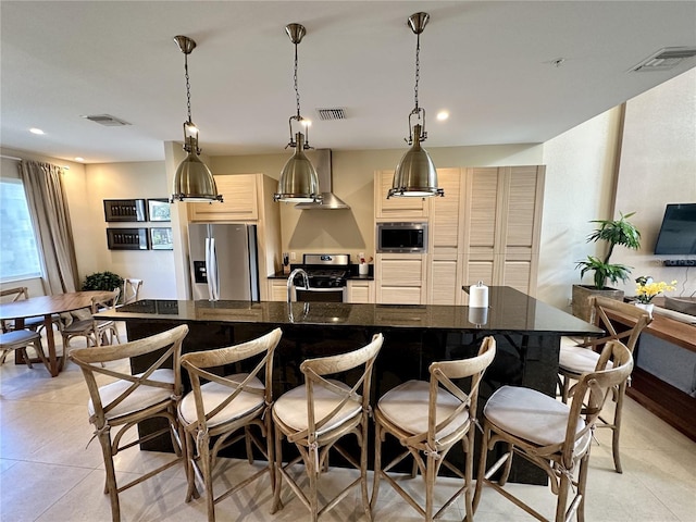 kitchen featuring visible vents, appliances with stainless steel finishes, and a breakfast bar area