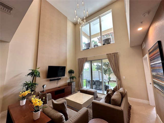 living room with light tile patterned floors, an inviting chandelier, and a high ceiling