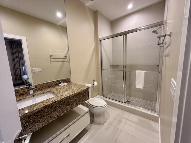 bathroom with tile patterned flooring, toilet, vanity, and a stall shower